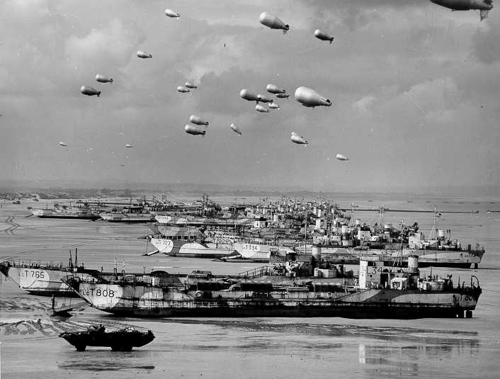 British LCT's line the Normandy shore, each with a barrage balloon designed to discourage enemy air attack. British LCT's line the Normandy shore, each with a barrage balloon designed to discourage enemy air attack.